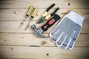herramientas y guantes en mesa de madera foto