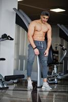Fit and muscular arabian man posing in gym. photo