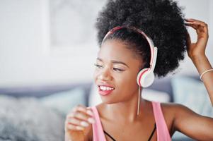 Young african american woman listen music on earphones. photo