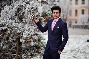 Elegant indian macho man model on suit and pink tie posed on winter day. photo