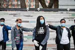 Group of african teenagers friends wearing medical masks protect from infections and diseases coronavirus virus quarantine. photo