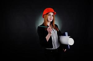 Engineer woman in orange protect helmet with construction paper projekt. photo