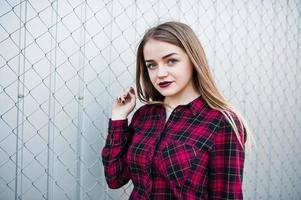 Young hipster girl in checkered shirt posed outdoor. photo