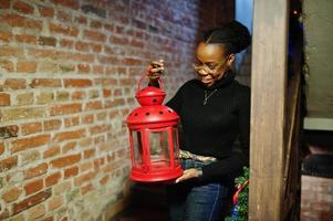 African woman in black sweater with red christmas lantern. photo