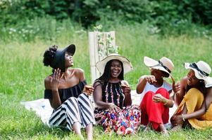 Group of african american girls celebrating birthday party and eat muffins outdoor with decor. photo