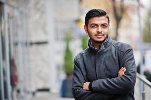 Stylish indian hindu man in gray coat posed on street. photo