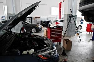 Car repair and maintenance theme. Car open hood engine in auto service. photo