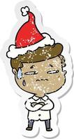 distressed sticker cartoon of a anxious man wearing santa hat vector