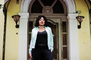 Stylish african american plus size model at streets of city against enter of house. photo