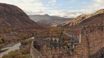 una turista camina por el sendero rodeado de ruinas de la muralla de la fortaleza de khertvisi. filtro cinematográfico y concepto de viaje video