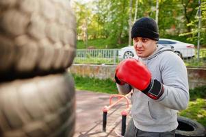 Man arabian boxer in hat training for a hard fight outdoor gym. photo