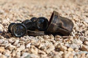 old binoculars on pebbles photo