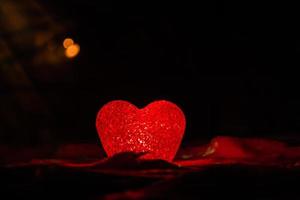 Glowing red heart in darkness symbolic of love photo