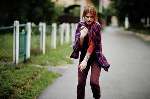 retrato de moda de chica sexy pelirroja al aire libre. modelo atractiva mujer de seducción con cigarrillo. foto