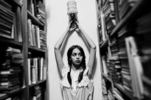 Girl with pigtails in white blouse at old library. photo