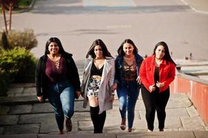 Group of four happy and pretty latino girls from Ecuador posed at street. photo