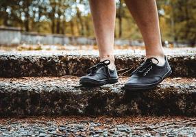 legs of a person standing in a public park photo