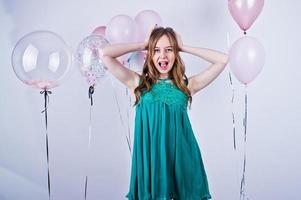 Happy girl in green turqoise dress with colored balloons isolated on white. Celebrating birthday theme. photo