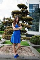 Teenage girl in blue dress posed outdoor at sunny day. photo