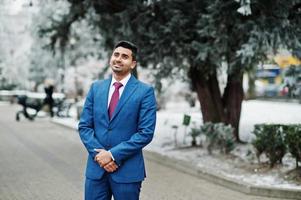 elegante modelo de hombre de moda indio en traje posado en el día de invierno. foto