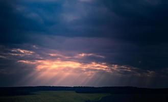 sunset with clouds and sunbeams photo