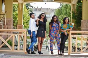 grupo de cuatro chicas afroamericanas posaron al aire libre contra la terraza de verano del restaurante de la ciudad. foto