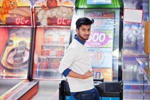 Young asian man play on fortune wheel slot machines to try win at lottery great prize. Gamble jackpot prize spin. Round drum casino money game. photo