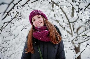 Portrait of girl at winter snowy day near snow covered trees. photo