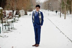 Stylish indian student man in suit, glasses and scarf posed at winter day outdoor. photo