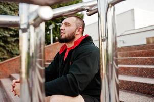 joven brutal hombre musculoso barbudo vestido con traje deportivo. foto