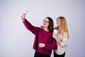 Two girls in purple dresses taking selfie in the studio. photo