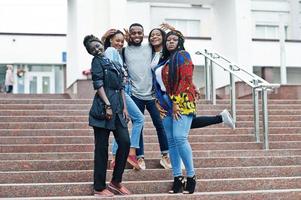 Group of five african college students spending time together on campus at university yard. Black afro friends studying. Education theme. photo