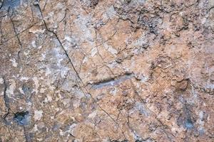 old weathered rock wall with beautiful cracks, pattern and texture, colorful background, textured surface photo