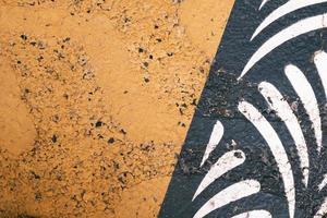 close up of painted in yellow road asphalt with decorative elements, pattern and texture, colorful background, weathered textured surface photo