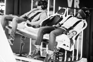 Two young indian people having fun with a new technology of a vr headset at virtual reality simulator. photo