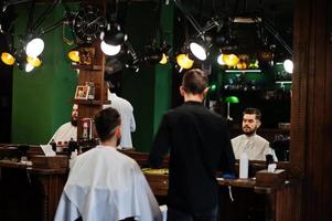 Handsome bearded man at the barbershop, barber at work. photo