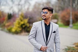 hombre indio elegante con bindi en la frente y anteojos, traje puesto al aire libre. foto