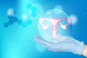 hands of a gynecologist doctor in gloves hold the uterus icon in the amniotic fluid as a symbol of female reproductive health, and medical icons on a blue medical background. Medical poster. photo