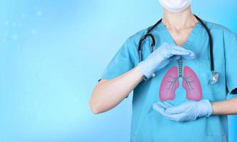 A doctor with a stethoscope holds an icon with human lungs in his hands. The concept of prevention of diseases of tuberculosis, lung cancer, pneumonia, coronavirus infection. Copy space. photo