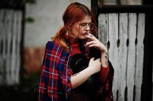 Fashion portrait of redhaired sexy girl outdoor. Model attractive seduction woman with cigarette. photo