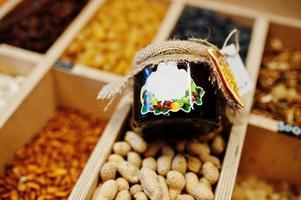 tarro casero con mermelada con cacahuetes en la estantería de un supermercado o tienda de comestibles. foto