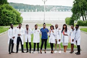 grupo de estudiantes de medicina africanos posaron al aire libre con batas blancas de laboratorio. foto