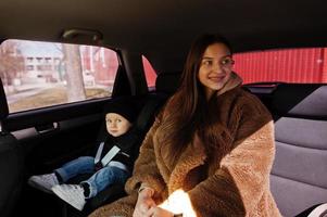 Young mother and child in car. Baby seat on chair. Safety driving concept. photo