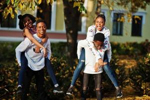 Four african friends walking the streets of an ancient city at autumn sunny day. photo