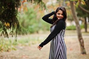 retrato de una joven y hermosa adolescente india o del sur de asia vestida en un parque de otoño en europa. foto