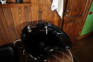 Black washbasin or sink at barber shop. photo