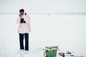 African american fisherman on frozen sea. Winter fishing. photo