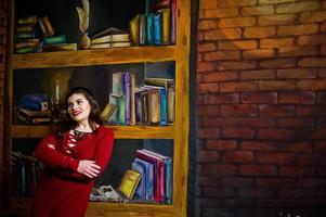 Brunette plus size model against wall like library. photo