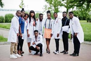 grupo de estudiantes de medicina africanos posaron al aire libre con batas blancas de laboratorio. foto