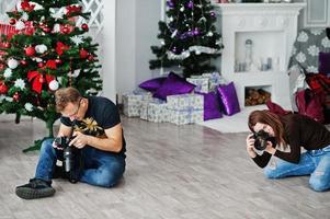 el equipo de dos fotógrafos disparando en el estudio. fotógrafo profesional en el trabajo. foto